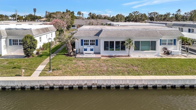 9822 Desoto Ct, Bradenton, FL 34210 - back of property featuring a water view, a yard, stucco siding, and a patio area