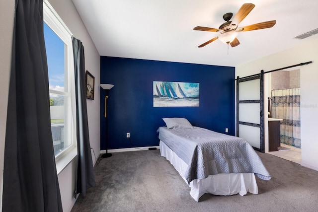 4739 Reisswood Loop, Palmetto, FL 34221 - bedroom with carpet floors, a barn door, ceiling fan, and an accent wall