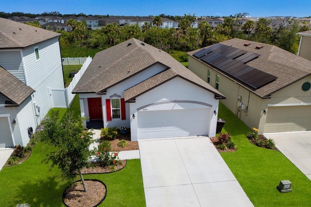 4739 Reisswood Loop, Palmetto, FL 34221 - ranch-style house with a residential view, an attached garage, driveway, roof mounted solar panels, and stucco siding