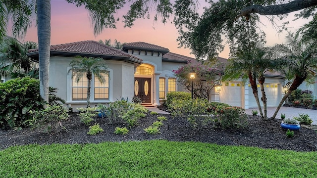 6914 Dominion Ln, Lakewood Ranch, FL 34202 - mediterranean / spanish-style home with french doors, stucco siding, driveway, and an attached garage