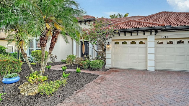 6914 Dominion Ln, Lakewood Ranch, FL 34202 - mediterranean / spanish-style house with stucco siding, a tile roof, decorative driveway, and a garage