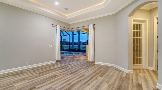 6914 Dominion Ln, Lakewood Ranch, FL 34202 - unfurnished room with light wood-style flooring, arched walkways, ornamental molding, baseboards, and a sunroom