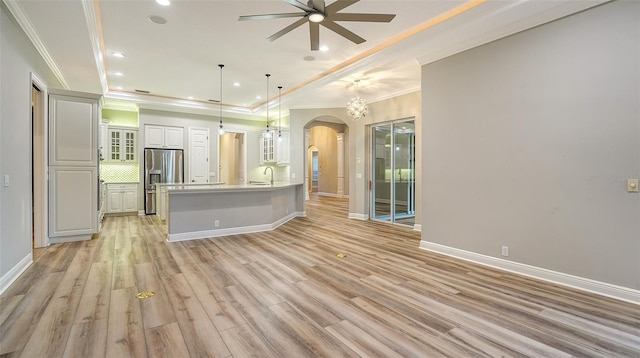 6914 Dominion Ln, Lakewood Ranch, FL 34202 - unfurnished living room with arched walkways, a ceiling fan, ornamental molding, a sink, and recessed lighting