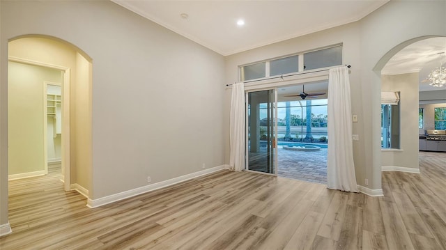 6914 Dominion Ln, Lakewood Ranch, FL 34202 - spare room with light wood-type flooring, crown molding, arched walkways, a ceiling fan, and baseboards