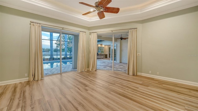 6914 Dominion Ln, Lakewood Ranch, FL 34202 - unfurnished room with a tray ceiling, a ceiling fan, light wood-style floors, ornamental molding, and baseboards