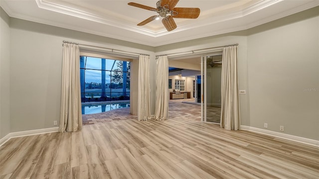 6914 Dominion Ln, Lakewood Ranch, FL 34202 - empty room with a raised ceiling, ornamental molding, light wood-style floors, ceiling fan, and baseboards