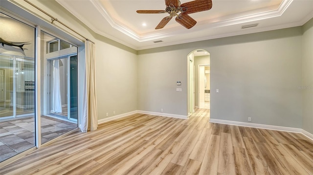 6914 Dominion Ln, Lakewood Ranch, FL 34202 - spare room with a tray ceiling, ornamental molding, arched walkways, light wood-style flooring, and ceiling fan