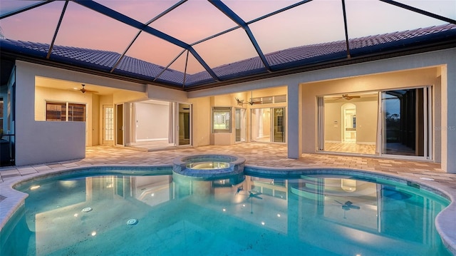 6914 Dominion Ln, Lakewood Ranch, FL 34202 - pool at dusk featuring ceiling fan, a patio, a pool with connected hot tub, and a lanai