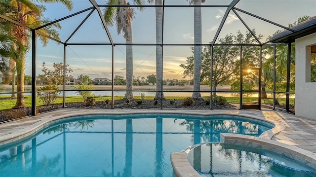 6914 Dominion Ln, Lakewood Ranch, FL 34202 - pool at dusk featuring a lanai, a pool with connected hot tub, and a patio
