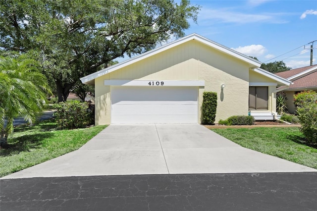 4109 Carriage Dr Unit 23, Sarasota, FL 34241 - view of front of house featuring a garage, a front lawn, and stucco siding