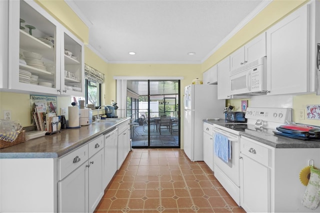 4109 Carriage Dr Unit 23, Sarasota, FL 34241 - kitchen with white appliances, ornamental molding, white cabinets, a sink, and dark countertops