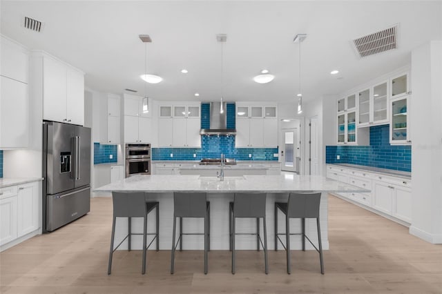 7051 Turtle Ln, Sarasota, FL 34241 - kitchen with appliances with stainless steel finishes, tasteful backsplash, wall chimney exhaust hood, white cabinetry, and recessed lighting