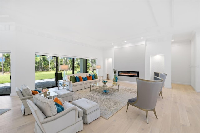 7051 Turtle Ln, Sarasota, FL 34241 - living room featuring plenty of natural light, recessed lighting, light wood-style floors, a glass covered fireplace, and a high ceiling