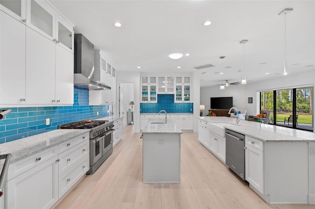 7051 Turtle Ln, Sarasota, FL 34241 - kitchen with a large island, stainless steel appliances, wall chimney exhaust hood, backsplash, and ceiling fan