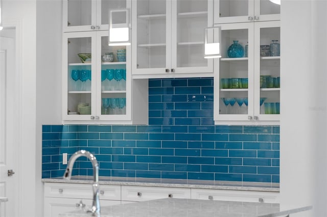 7051 Turtle Ln, Sarasota, FL 34241 - kitchen with white cabinetry, decorative backsplash, and glass insert cabinets