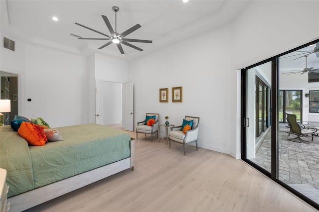 7051 Turtle Ln, Sarasota, FL 34241 - bedroom featuring access to outside, light wood-style floors, a towering ceiling, recessed lighting, and a tray ceiling
