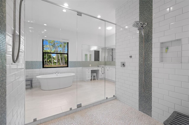 7051 Turtle Ln, Sarasota, FL 34241 - bathroom with tile walls, tiled shower, a soaking tub, vanity, and tile patterned floors