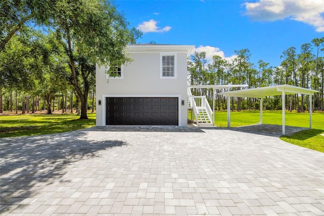 7051 Turtle Ln, Sarasota, FL 34241 - view of front facade featuring decorative driveway, stairway, a front yard, an attached garage, and a carport