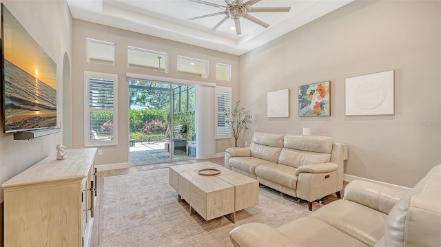 11603 Bluebird Pl, Lakewood Ranch, FL 34211 - living area with a ceiling fan, light wood-style floors, baseboards, a high ceiling, and a tray ceiling