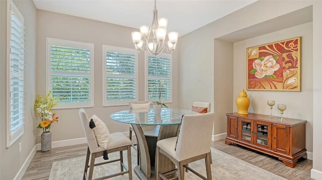 11603 Bluebird Pl, Lakewood Ranch, FL 34211 - dining area with wood finished floors, a chandelier, and baseboards