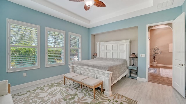 11603 Bluebird Pl, Lakewood Ranch, FL 34211 - bedroom featuring arched walkways, ceiling fan, a tray ceiling, and baseboards