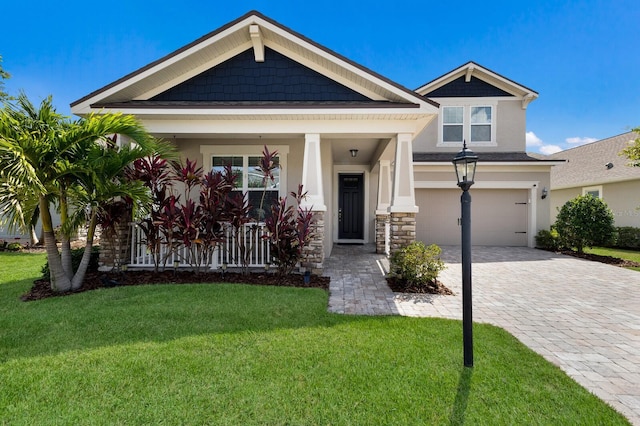 11411 Spring Gate Trl, Bradenton, FL 34211 - craftsman-style house featuring a garage, a front lawn, stucco siding, decorative driveway, and covered porch