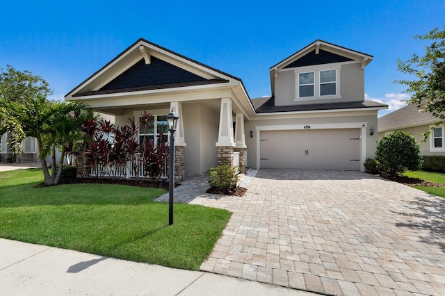 11411 Spring Gate Trl, Bradenton, FL 34211 - craftsman inspired home with stucco siding, decorative driveway, a front lawn, an attached garage, and stone siding