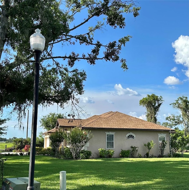 3192 Oaks Bnd, Bowling Green, FL 33834 - view of side of home featuring stucco siding and a yard