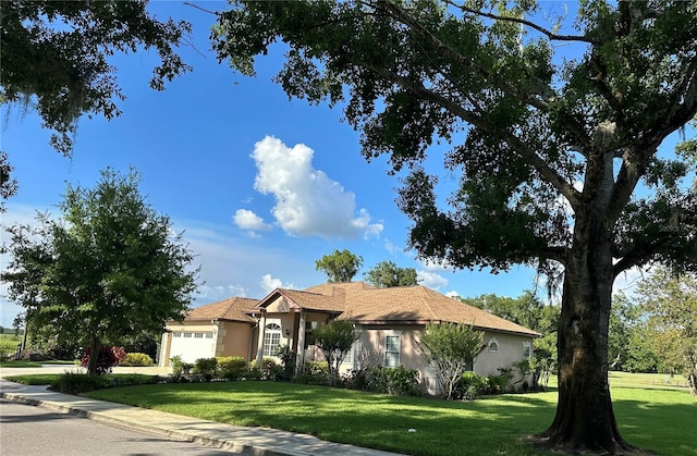 3192 Oaks Bnd, Bowling Green, FL 33834 - view of front facade with stucco siding, a garage, and a front yard
