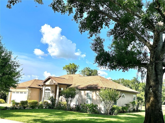 3192 Oaks Bnd, Bowling Green, FL 33834 - ranch-style house with stucco siding, an attached garage, and a front lawn