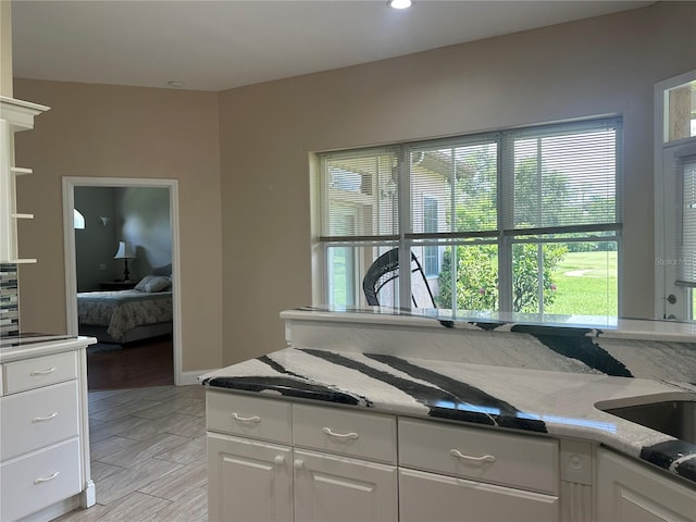 3192 Oaks Bnd, Bowling Green, FL 33834 - kitchen featuring white cabinets, wood tiled floors, light stone countertops, and recessed lighting
