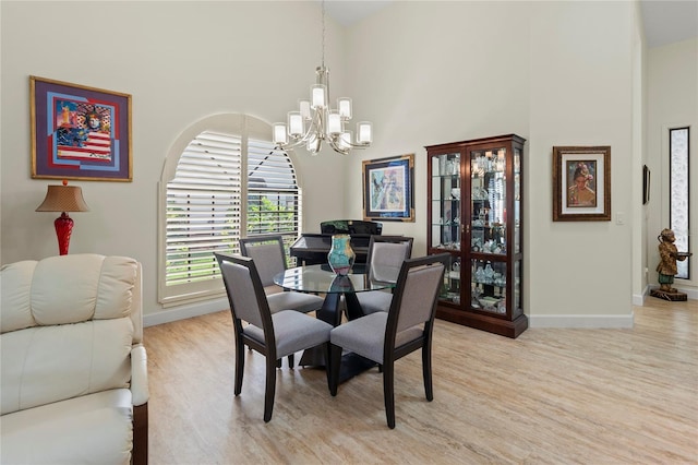 7331 Villa D Este Dr, Sarasota, FL 34238 - dining room featuring a chandelier, light wood finished floors, baseboards, and a high ceiling