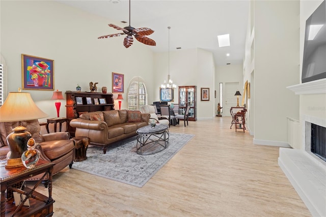 7331 Villa D Este Dr, Sarasota, FL 34238 - living area with a high ceiling, a chandelier, light wood-type flooring, a fireplace with raised hearth, and a ceiling fan