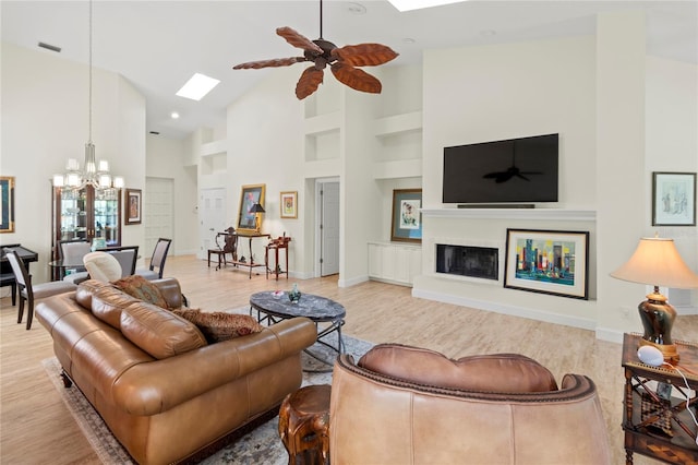 7331 Villa D Este Dr, Sarasota, FL 34238 - living room featuring a skylight, a chandelier, high vaulted ceiling, wood finished floors, and built in features