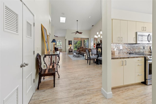 7331 Villa D Este Dr, Sarasota, FL 34238 - kitchen with stainless steel appliances, high vaulted ceiling, light wood finished floors, a ceiling fan, and tasteful backsplash