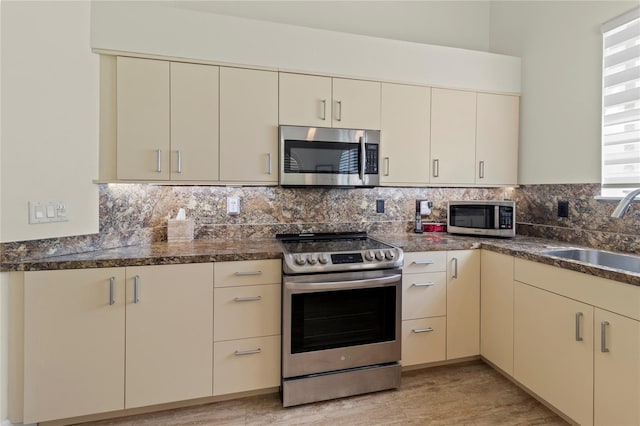 7331 Villa D Este Dr, Sarasota, FL 34238 - kitchen featuring stainless steel appliances, a sink, cream cabinetry, and backsplash