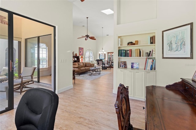 7331 Villa D Este Dr, Sarasota, FL 34238 - home office featuring high vaulted ceiling, light wood finished floors, ceiling fan, baseboards, and built in shelves