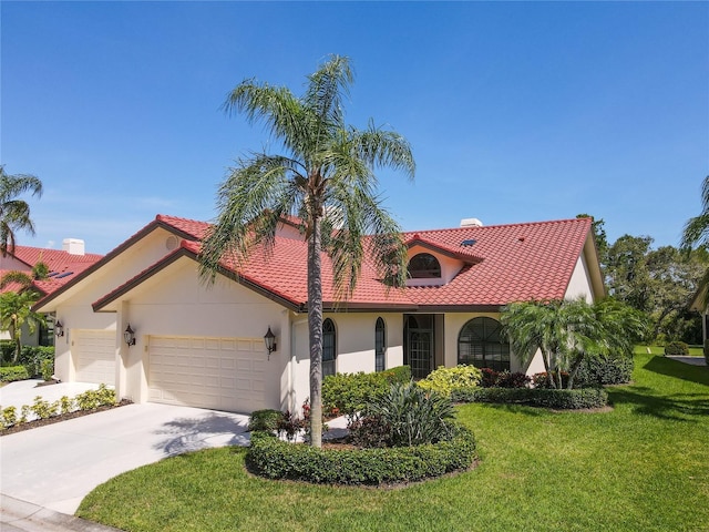 7331 Villa D Este Dr, Sarasota, FL 34238 - mediterranean / spanish house with an attached garage, stucco siding, a front lawn, a tiled roof, and concrete driveway