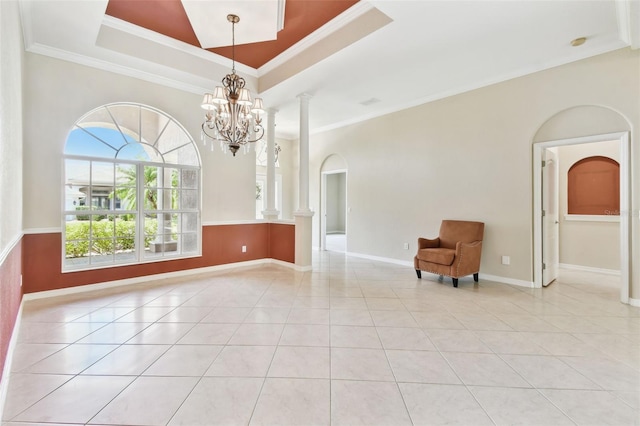 9008 Brookfield Ter, Bradenton, FL 34212 - spare room featuring decorative columns, arched walkways, crown molding, light tile patterned floors, and baseboards