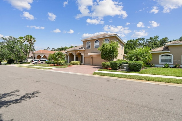 9008 Brookfield Ter, Bradenton, FL 34212 - mediterranean / spanish-style house with an attached garage, driveway, stucco siding, and a tiled roof