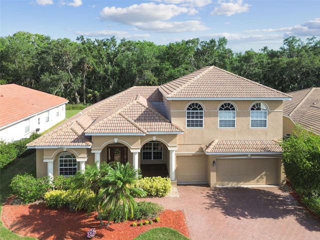 9008 Brookfield Ter, Bradenton, FL 34212 - mediterranean / spanish-style house featuring a garage, stucco siding, a tiled roof, and decorative driveway