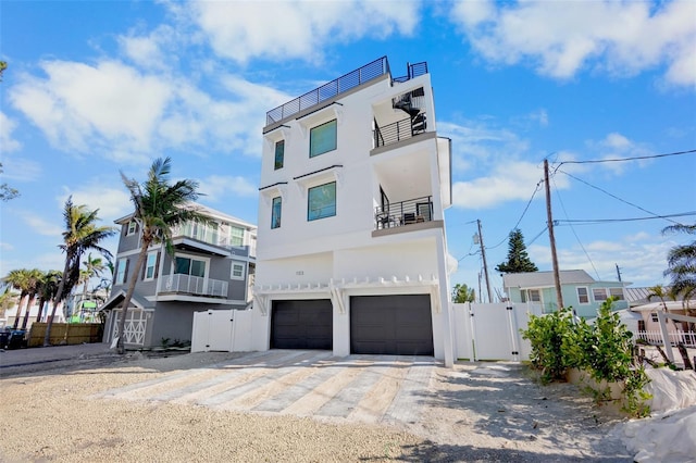 103 4th St N Unit A, Bradenton Beach, FL 34217 - view of front facade with a gate, an attached garage, stucco siding, and driveway