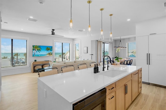 103 4th St N Unit A, Bradenton Beach, FL 34217 - kitchen featuring a sink, light wood-style floors, light countertops, decorative light fixtures, and healthy amount of natural light