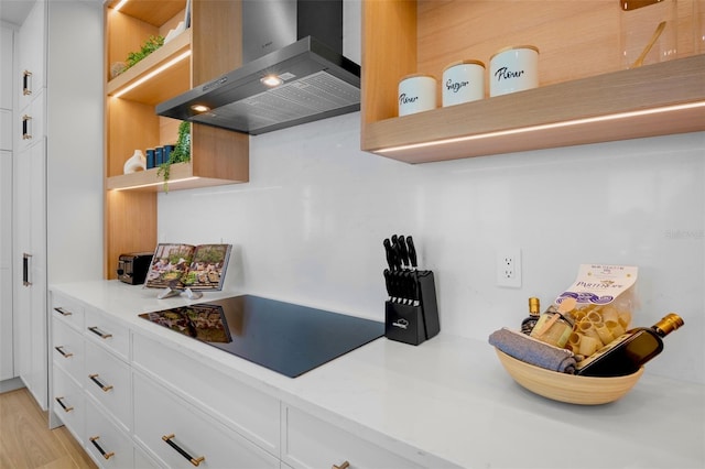 103 4th St N Unit A, Bradenton Beach, FL 34217 - kitchen with open shelves, wall chimney exhaust hood, black electric cooktop, white cabinets, and light countertops