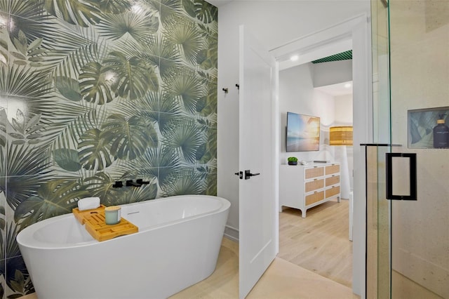 103 4th St N Unit A, Bradenton Beach, FL 34217 - full bath featuring a soaking tub, wood finished floors, and a stall shower