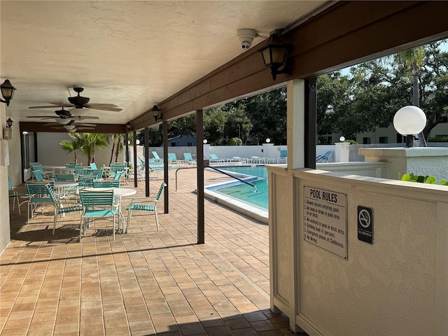 2841 74th St W Unit 2841, Bradenton, FL 34209 - fenced backyard featuring a ceiling fan, a community pool, and outdoor dining space