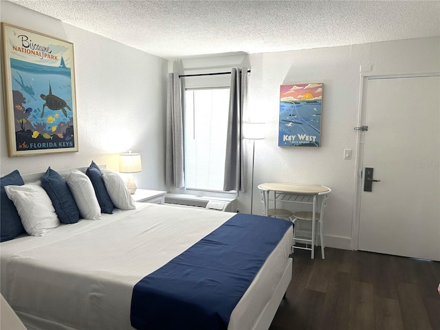 7150 N Tamiami Trl Unit C100, Sarasota, FL 34243 - bedroom featuring a textured ceiling and wood finished floors