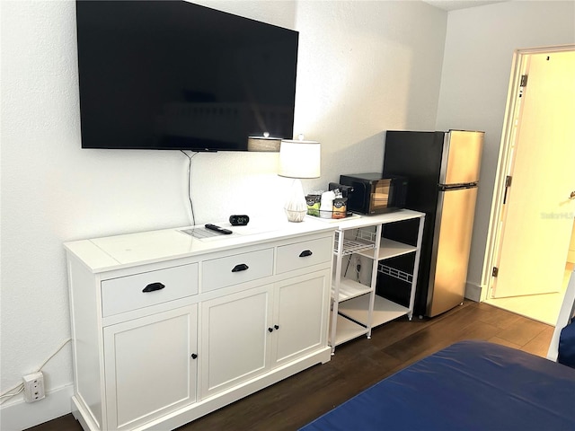 7150 N Tamiami Trl Unit C100, Sarasota, FL 34243 - bedroom featuring freestanding refrigerator and dark wood-type flooring