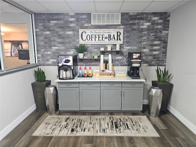 7150 N Tamiami Trl Unit C100, Sarasota, FL 34243 - indoor dry bar featuring a drop ceiling, baseboards, and dark wood-style flooring