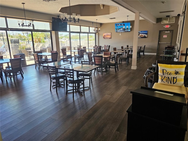 7150 N Tamiami Trl Unit C100, Sarasota, FL 34243 - dining area featuring a chandelier and dark wood-type flooring